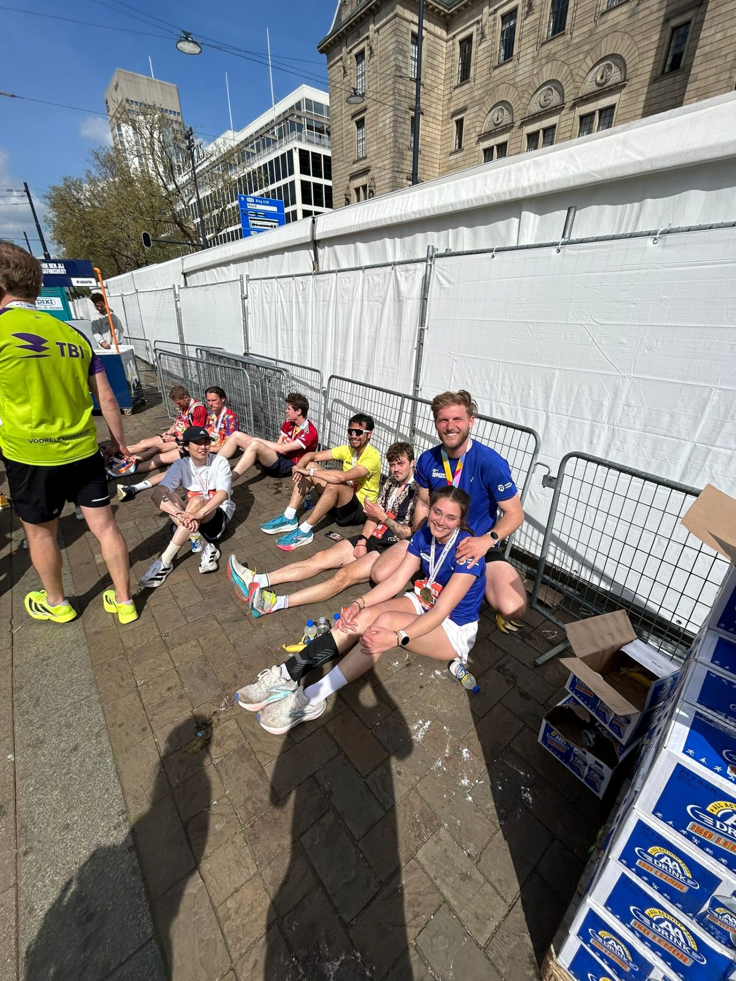 Greg and friends sitting on the ground after finishing the Rotterdam marathon